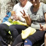 Dos mujeres sentadas en una calle sonrriendo