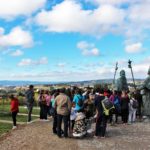 Gente en un mirador con dos estatuas